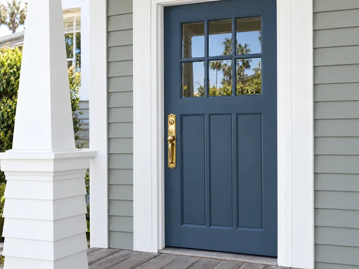 After: The same entry with a deep slate-blue door and repaired crisp white trim